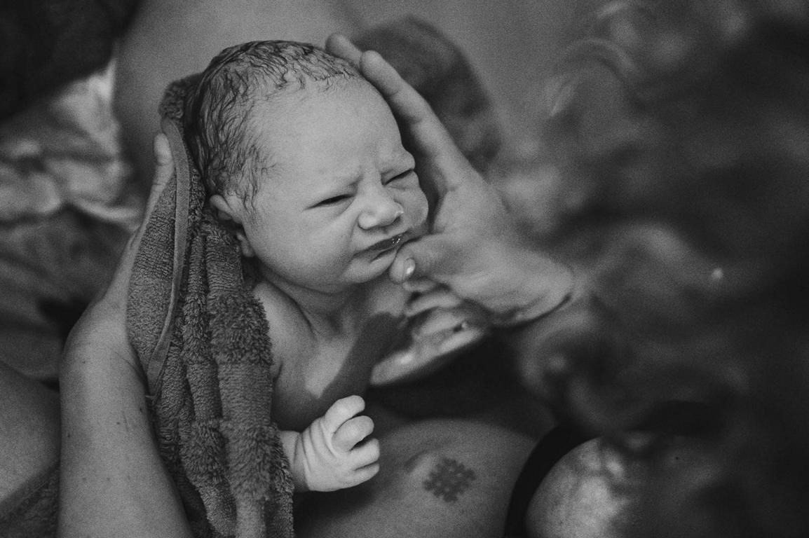 Schwarz-Weiß-Bild eines Neugeborenen.