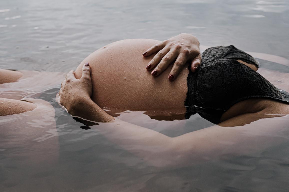 Natürliches Babybauchfoto im Wasser.
